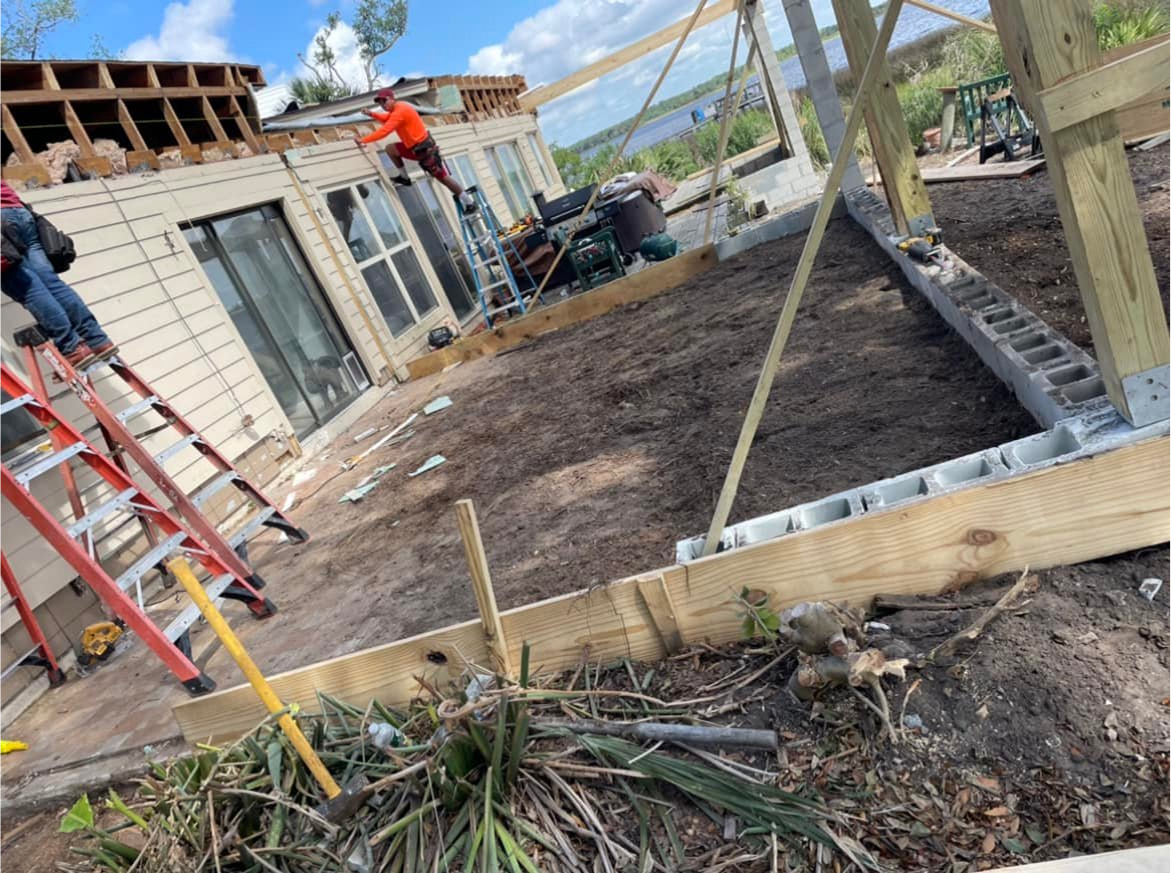 Workers from Ernest Concrete preparing to pour a concrete patio while a house is being built