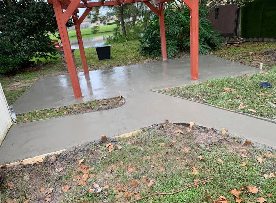 Freshly poured concrete on sidewalk and patio with red pergola