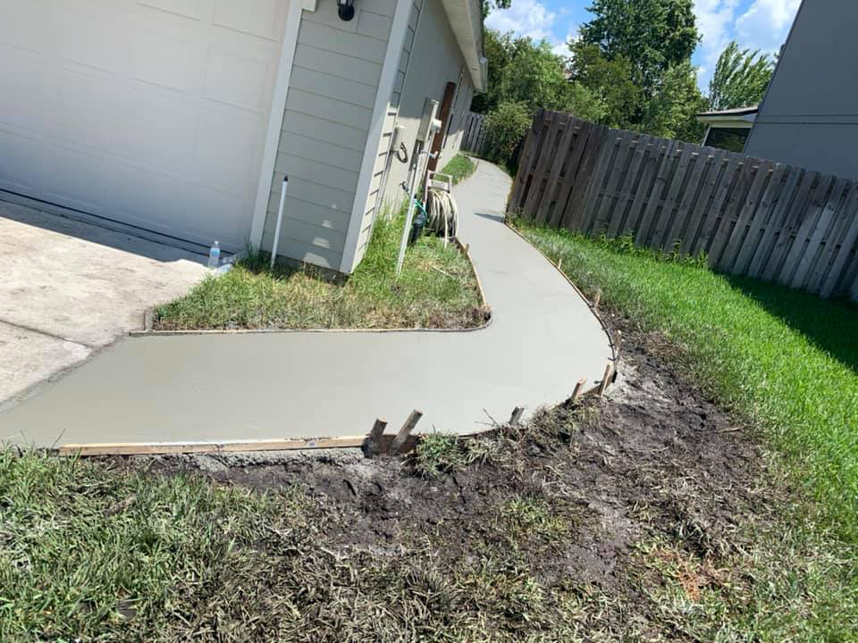 New concrete walkway from front of house to backyard